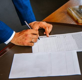 person writing on white form paper